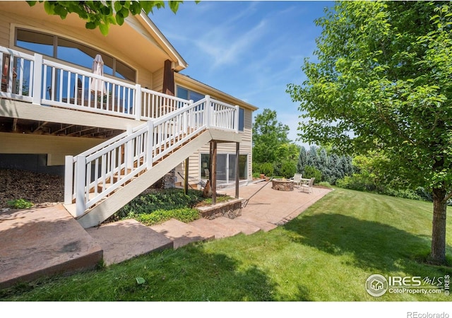 2156 Meander Rd, Windsor, CO 80550 - view of grassy yard with a patio area, an outdoor fire pit, a wooden deck, and stairs