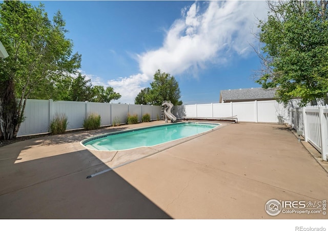 137 Reid Rd, Fort Morgan, CO 80701 - view of pool featuring a water slide, a patio, and a fenced backyard