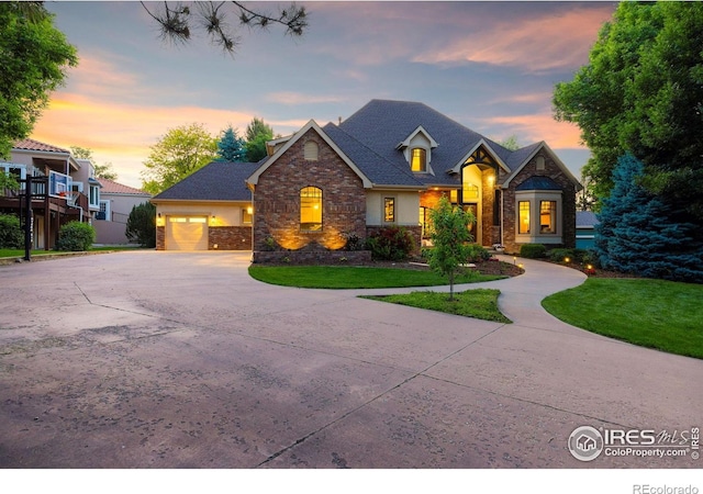 5424 Taylor Ln, Fort Collins, CO 80528 - view of front of property with stone siding, driveway, a yard, an attached garage, and stucco siding
