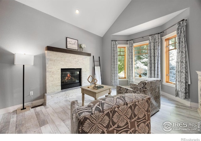 5424 Taylor Ln, Fort Collins, CO 80528 - living area featuring vaulted ceiling, a stone fireplace, and wood finished floors