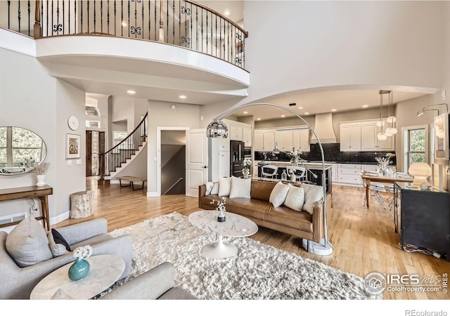 714 Skywalker Pt, Lafayette, CO 80026 - living room featuring a high ceiling, stairs, and light wood-type flooring