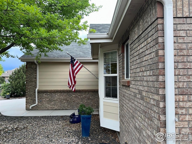 205 Timber Ridge Ct, Severance, CO 80550 - view of side of home with brick siding, roof with shingles, and a patio area