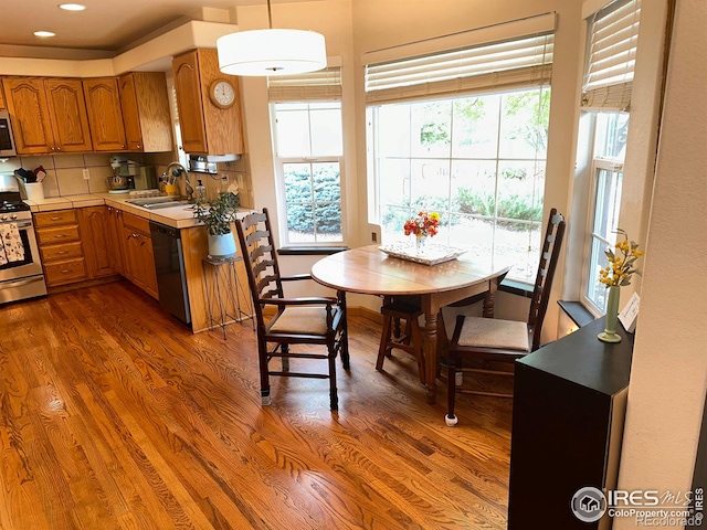 205 Timber Ridge Ct, Severance, CO 80550 - kitchen with appliances with stainless steel finishes, brown cabinets, dark wood finished floors, recessed lighting, and light countertops