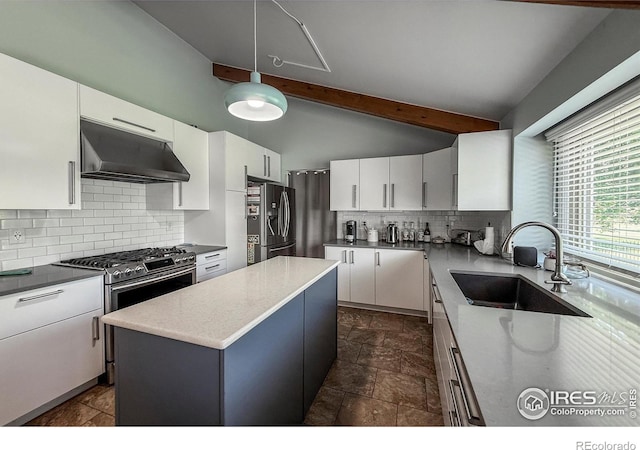 5004 Fox Hill Dr, Longmont, CO 80504 - kitchen featuring under cabinet range hood, appliances with stainless steel finishes, tasteful backsplash, white cabinets, and a kitchen island