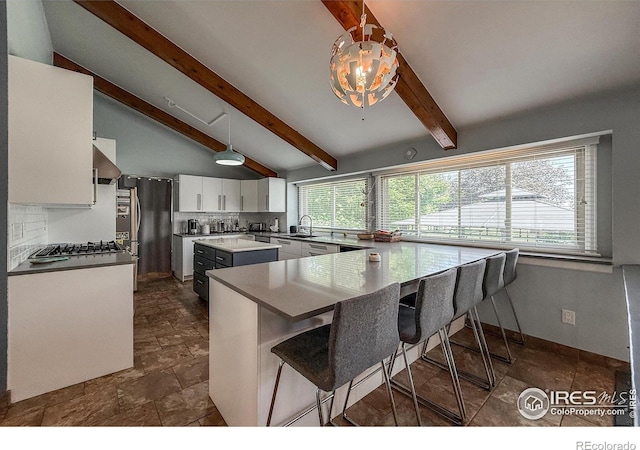 5004 Fox Hill Dr, Longmont, CO 80504 - kitchen with white cabinetry, a center island, wall chimney exhaust hood, a kitchen breakfast bar, and stainless steel appliances