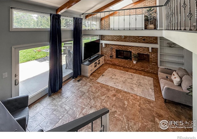 5004 Fox Hill Dr, Longmont, CO 80504 - living room featuring beamed ceiling, stone finish flooring, and a brick fireplace