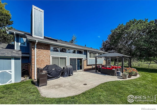 5004 Fox Hill Dr, Longmont, CO 80504 - rear view of house with brick siding, a patio, outdoor lounge area, a storage unit, and a gazebo
