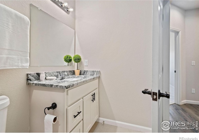 875 E 78th Ave Unit 53, Denver, CO 80229 - half bathroom with vanity and wood finished floors