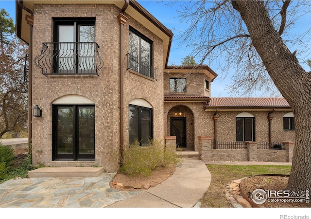 2111 E Alameda Ave, Denver, CO 80209 - view of front facade featuring a balcony, brick siding, and a tiled roof