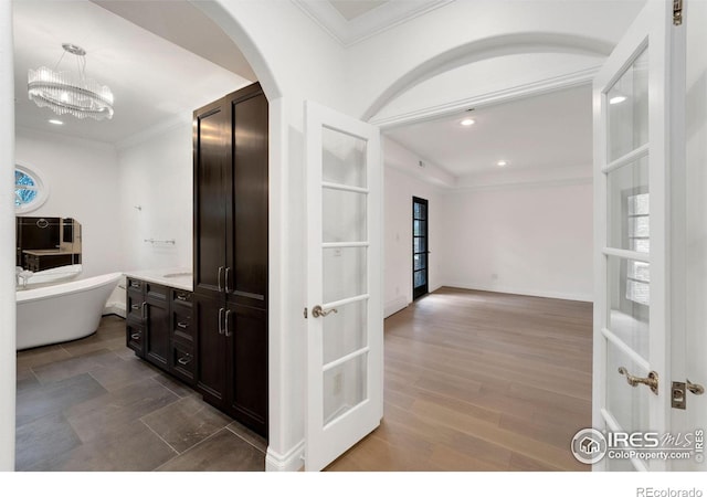 2111 E Alameda Ave, Denver, CO 80209 - hallway with crown molding, arched walkways, recessed lighting, a chandelier, and wood finished floors