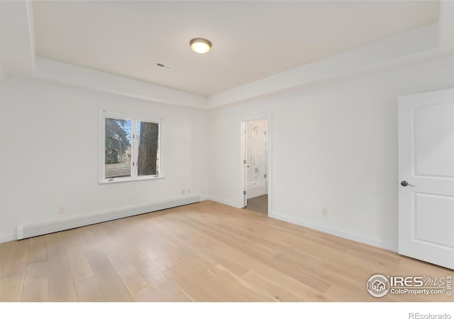 2111 E Alameda Ave, Denver, CO 80209 - spare room with a raised ceiling, light wood-style floors, and a baseboard radiator