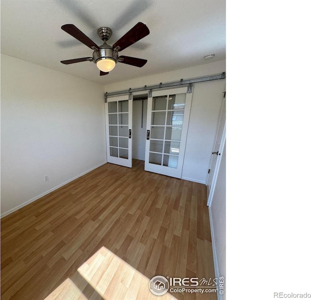 3025 Broadway St Unit 17, Boulder, CO 80304 - unfurnished room featuring a barn door, wood finished floors, and a ceiling fan