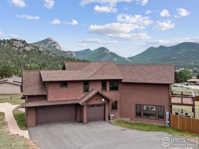 1740 N Ridge Ln, Estes Park, CO 80517 - view of front of house featuring stucco siding, an attached garage, a mountain view, and asphalt driveway