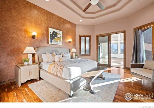 1740 N Ridge Ln, Estes Park, CO 80517 - bedroom featuring access to outside, wood finished floors, recessed lighting, a tray ceiling, and an accent wall