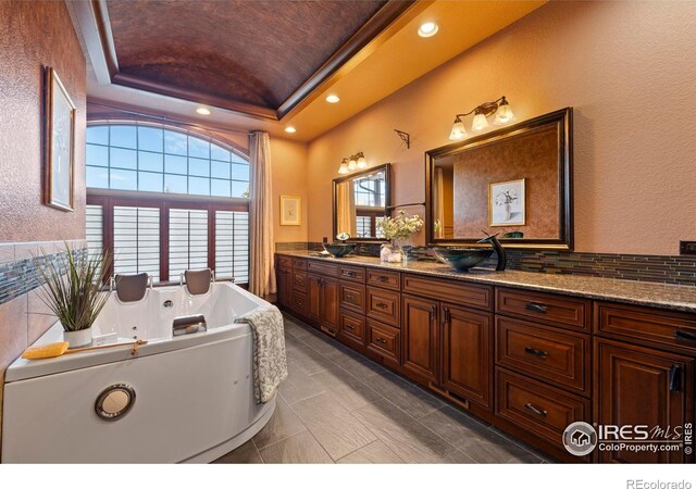 1740 N Ridge Ln, Estes Park, CO 80517 - full bathroom with a tray ceiling, double vanity, a jetted tub, recessed lighting, and tile patterned flooring