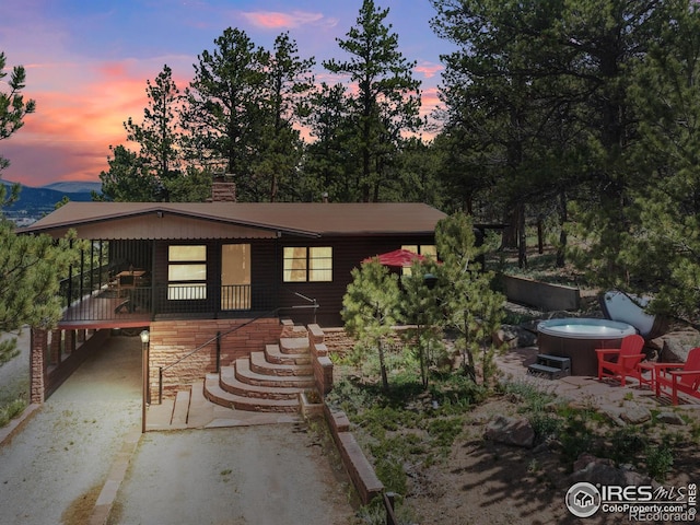1650 Powelly Ln, Estes Park, CO 80517 - view of front of house featuring a hot tub, stairway, a carport, and a chimney