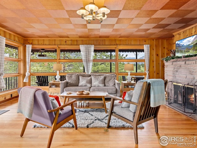 1650 Powelly Ln, Estes Park, CO 80517 - living room featuring wooden walls, a chandelier, a fireplace, and wood finished floors