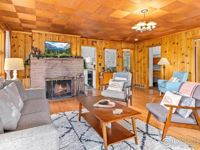 1650 Powelly Ln, Estes Park, CO 80517 - living area with wood walls, a chandelier, a fireplace, beverage cooler, and wood finished floors