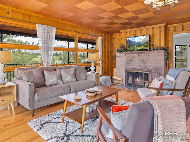 1650 Powelly Ln, Estes Park, CO 80517 - living room featuring healthy amount of natural light, a brick fireplace, wood walls, crown molding, and light wood-style floors