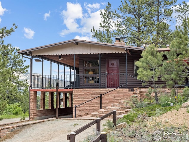 1650 Powelly Ln, Estes Park, CO 80517 - view of front of house with a chimney, stairway, covered porch, and log veneer siding