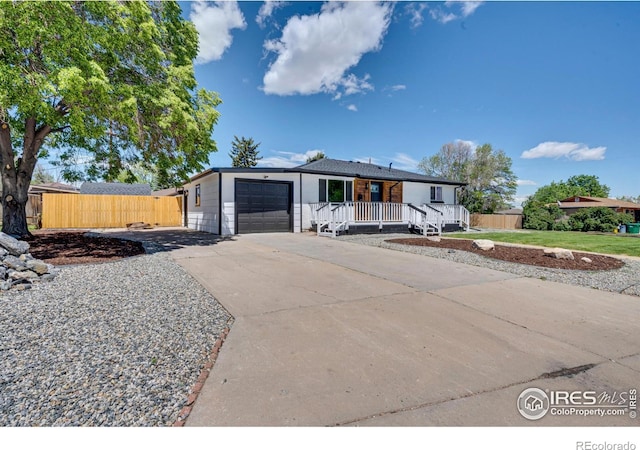 7826 Joan Dr, Denver, CO 80221 - view of front of house with a garage, concrete driveway, and a porch