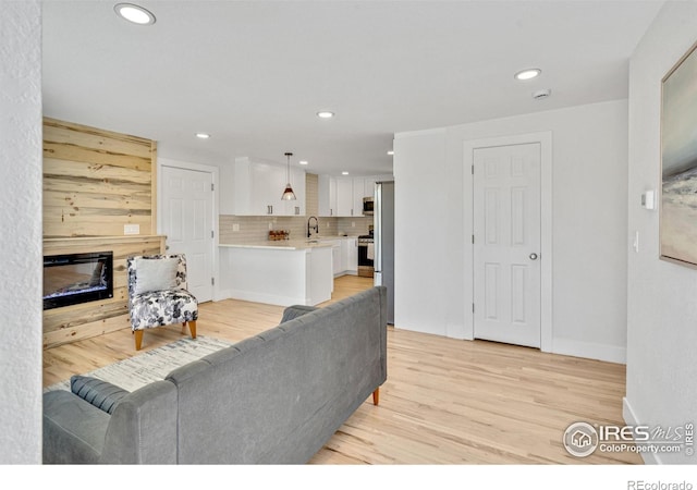 7826 Joan Dr, Denver, CO 80221 - living room featuring recessed lighting, a glass covered fireplace, and light wood finished floors