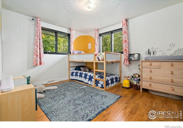 7423 Saulsbury St, Arvada, CO 80003 - bedroom with wood finished floors and multiple windows
