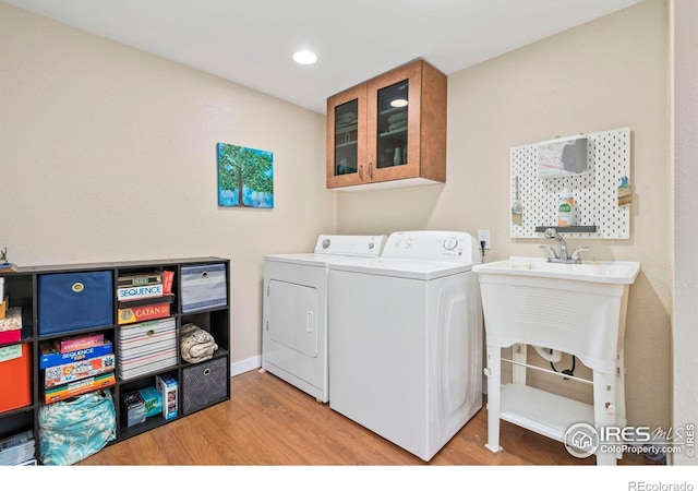 7423 Saulsbury St, Arvada, CO 80003 - laundry area with separate washer and dryer, wood finished floors, and recessed lighting