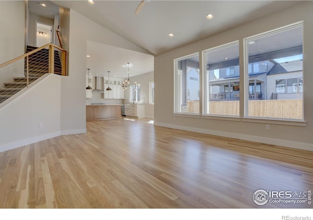 961 Eldorado Ln, Louisville, CO 80027 - unfurnished living room featuring lofted ceiling, light wood-style floors, stairs, a chandelier, and recessed lighting