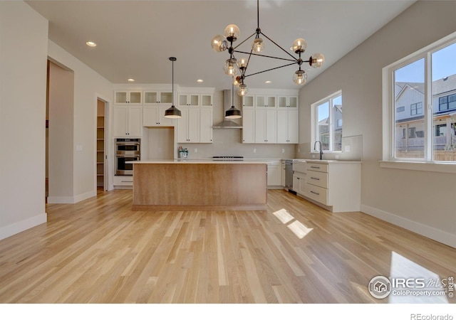 961 Eldorado Ln, Louisville, CO 80027 - kitchen featuring wall chimney exhaust hood, stainless steel appliances, recessed lighting, a kitchen island, and white cabinetry