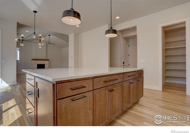 961 Eldorado Ln, Louisville, CO 80027 - kitchen featuring light wood finished floors, a fireplace, a chandelier, light countertops, and recessed lighting