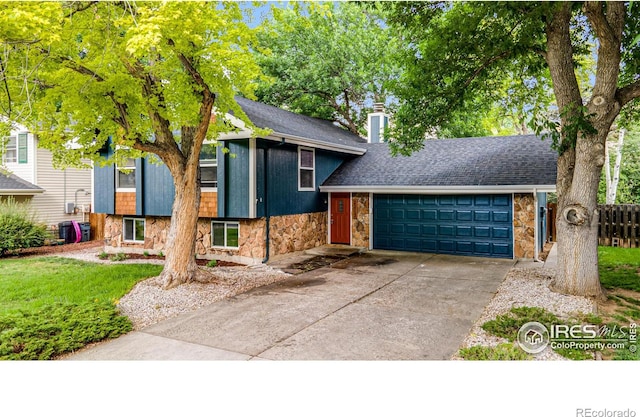 2213 Hiawatha Ct, Fort Collins, CO 80525 - tri-level home featuring stone siding, a garage, driveway, a chimney, and roof with shingles