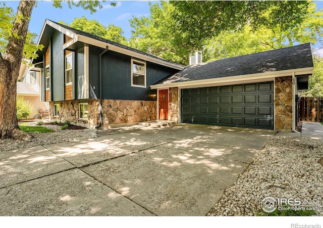 2213 Hiawatha Ct, Fort Collins, CO 80525 - tri-level home featuring stone siding, concrete driveway, an attached garage, and a chimney
