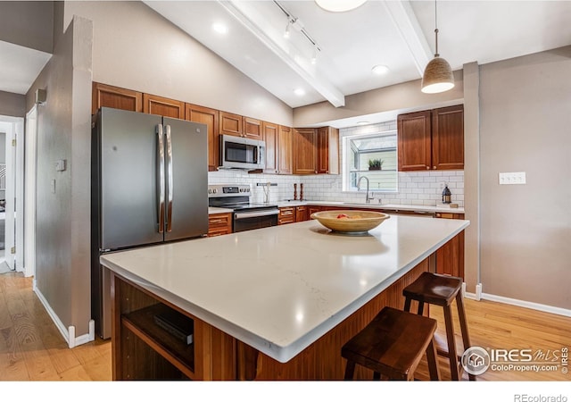 2213 Hiawatha Ct, Fort Collins, CO 80525 - kitchen with appliances with stainless steel finishes, light wood-style flooring, vaulted ceiling, tasteful backsplash, and light countertops