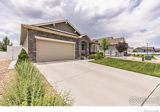 1897 Holloway Dr, Windsor, CO 80550 - view of front of home with stone siding, concrete driveway, board and batten siding, and an attached garage
