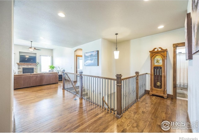 1897 Holloway Dr, Windsor, CO 80550 - corridor featuring wood finished floors, an upstairs landing, recessed lighting, and arched walkways