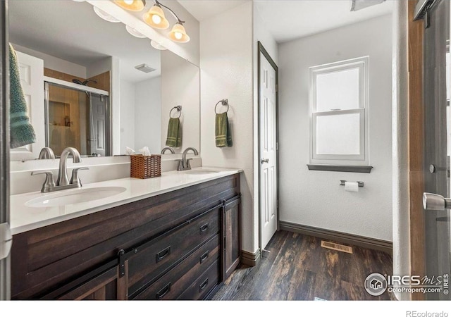 11861 Fairplay St, Commerce City, CO 80603 - full bathroom with wood finished floors, double vanity, and a stall shower