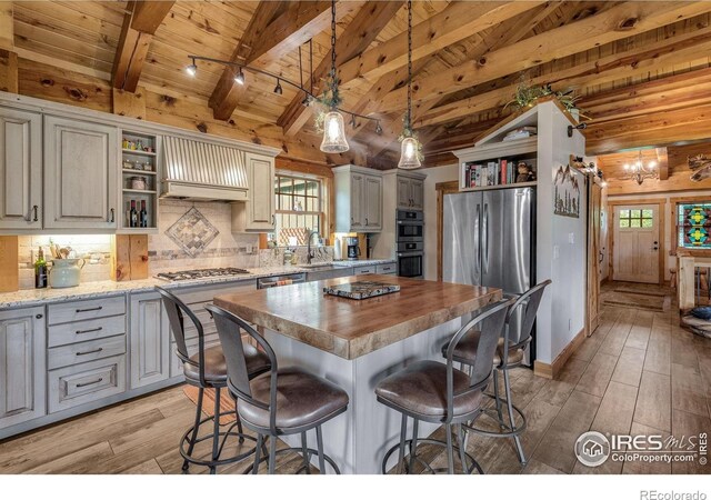 2055 Siskin Dr, Estes Park, CO 80517 - kitchen with open shelves, appliances with stainless steel finishes, light wood-type flooring, premium range hood, and wooden ceiling