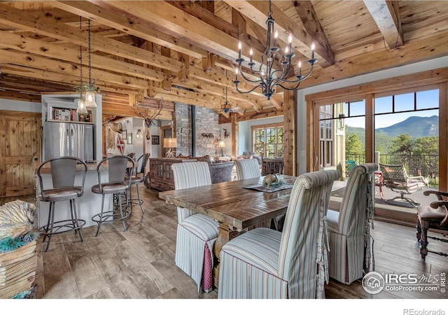 2055 Siskin Dr, Estes Park, CO 80517 - dining area featuring light wood finished floors, a chandelier, a wooden ceiling with exposed beams, and a mountain view