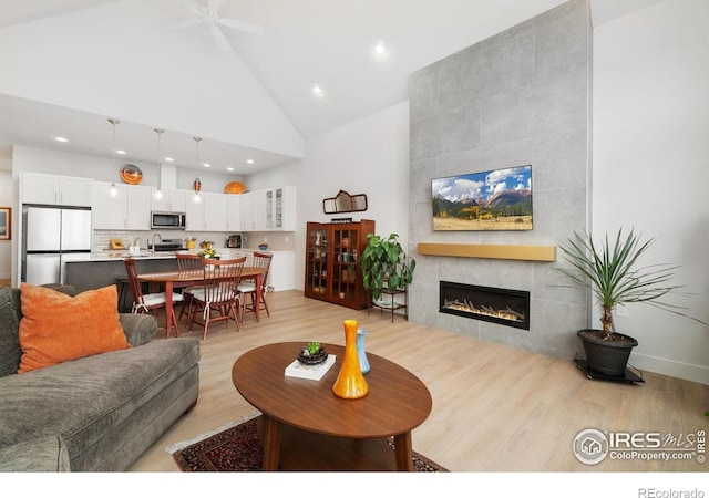 1911 Morningstar Way Unit 2, Fort Collins, CO 80524 - living area featuring high vaulted ceiling, light wood finished floors, a tile fireplace, ceiling fan, and recessed lighting