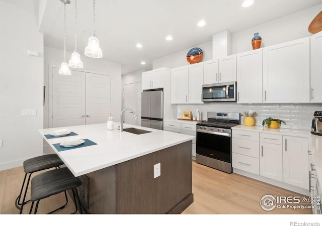 1911 Morningstar Way Unit 2, Fort Collins, CO 80524 - kitchen with stainless steel appliances, a breakfast bar, light wood-type flooring, tasteful backsplash, and recessed lighting