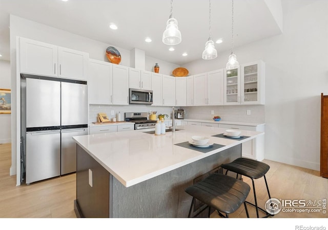 1911 Morningstar Way Unit 2, Fort Collins, CO 80524 - kitchen with appliances with stainless steel finishes, tasteful backsplash, light wood finished floors, white cabinets, and recessed lighting
