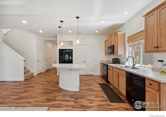 5104 Silverwood Dr, Johnstown, CO 80534 - kitchen featuring black appliances, a center island, wood finished floors, recessed lighting, and light countertops