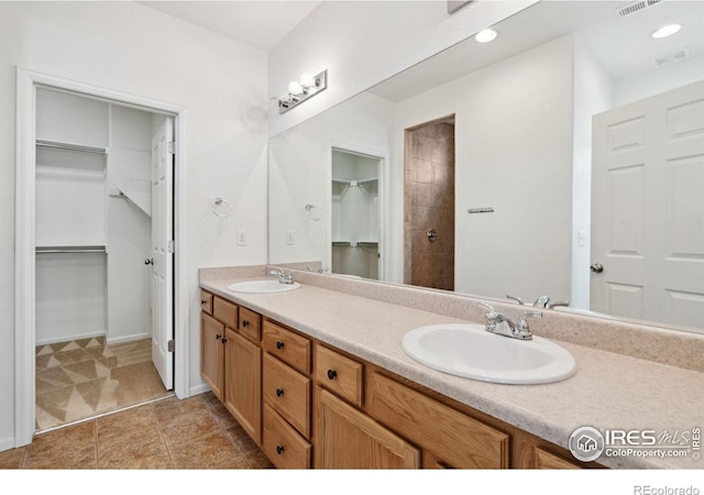 5104 Silverwood Dr, Johnstown, CO 80534 - full bathroom with double vanity, a spacious closet, tile patterned flooring, and tiled shower