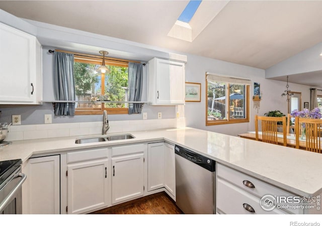 1967 Rangely Ct, Loveland, CO 80538 - kitchen featuring appliances with stainless steel finishes, white cabinets, lofted ceiling, a peninsula, and a skylight