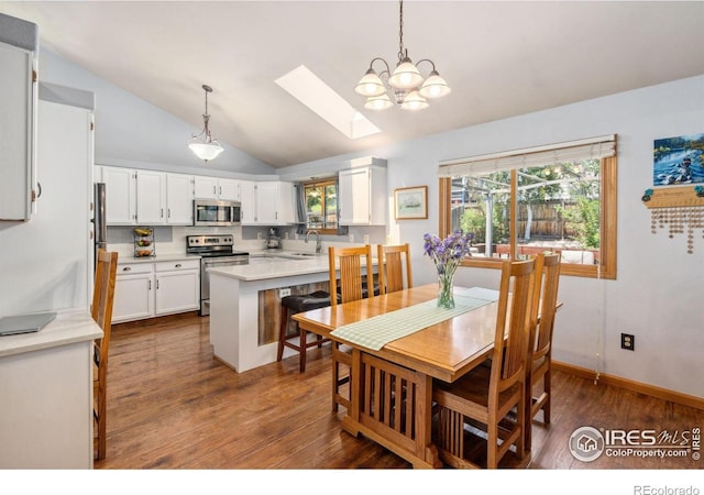 1967 Rangely Ct, Loveland, CO 80538 - dining area featuring a skylight, vaulted ceiling, dark wood finished floors, and a chandelier