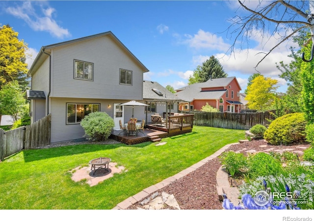 1967 Rangely Ct, Loveland, CO 80538 - rear view of house with a fire pit, a fenced backyard, and a deck