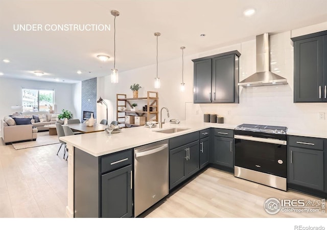 2744 Bear Springs Cir, Longmont, CO 80503 - kitchen with appliances with stainless steel finishes, wall chimney range hood, a peninsula, light wood-type flooring, and open floor plan