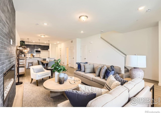 2744 Bear Springs Cir, Longmont, CO 80503 - living room with light wood-type flooring, recessed lighting, stairs, and a brick fireplace