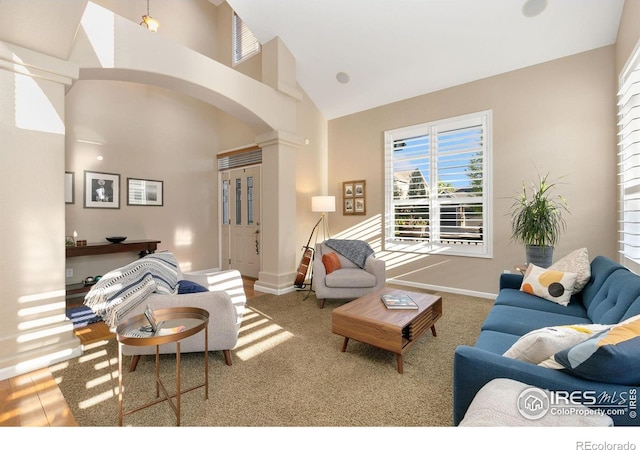 6582 Spanish Bay Dr, Windsor, CO 80550 - living area featuring arched walkways, a high ceiling, plenty of natural light, and carpet